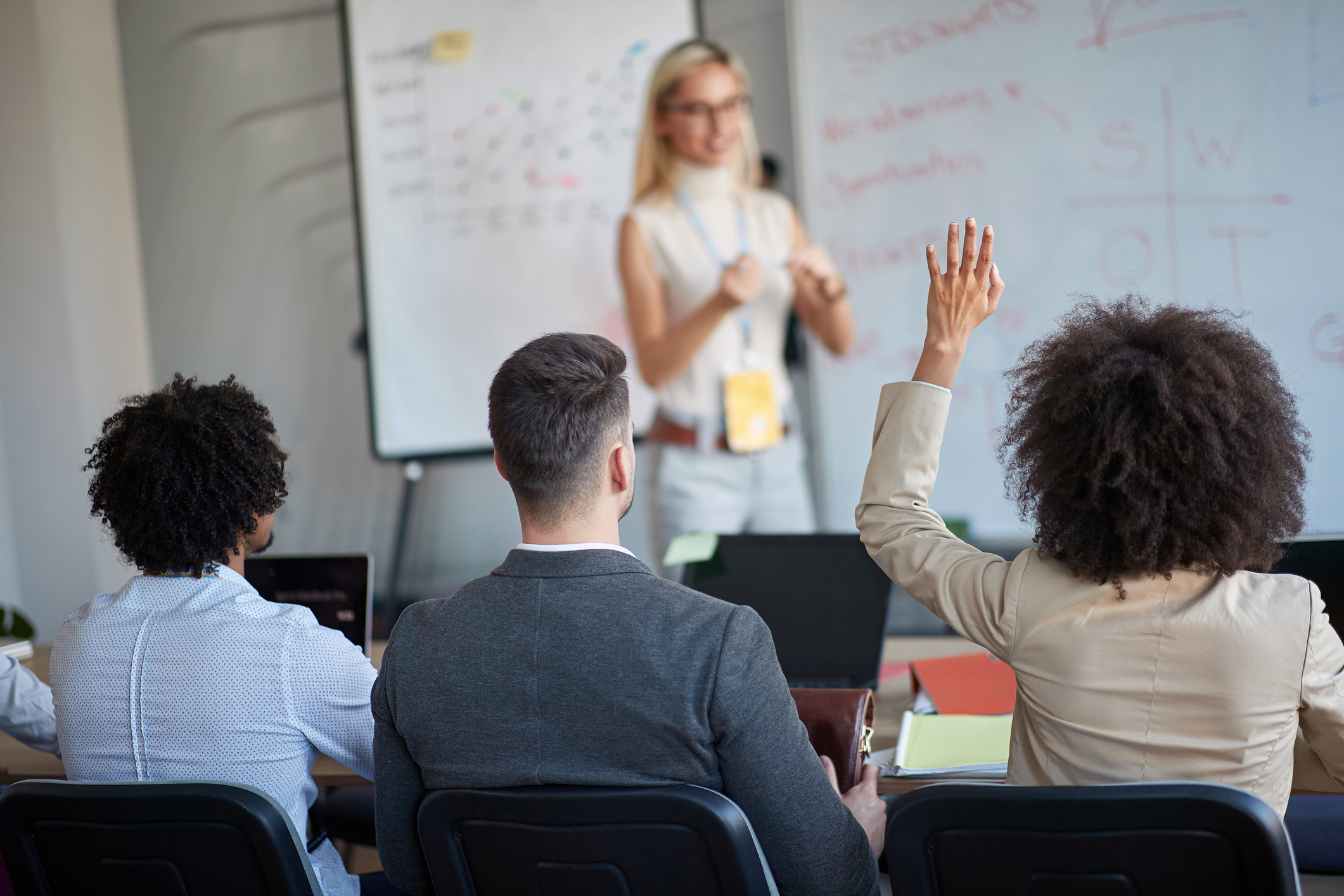 woman teaching a group in front of a whiteboard 