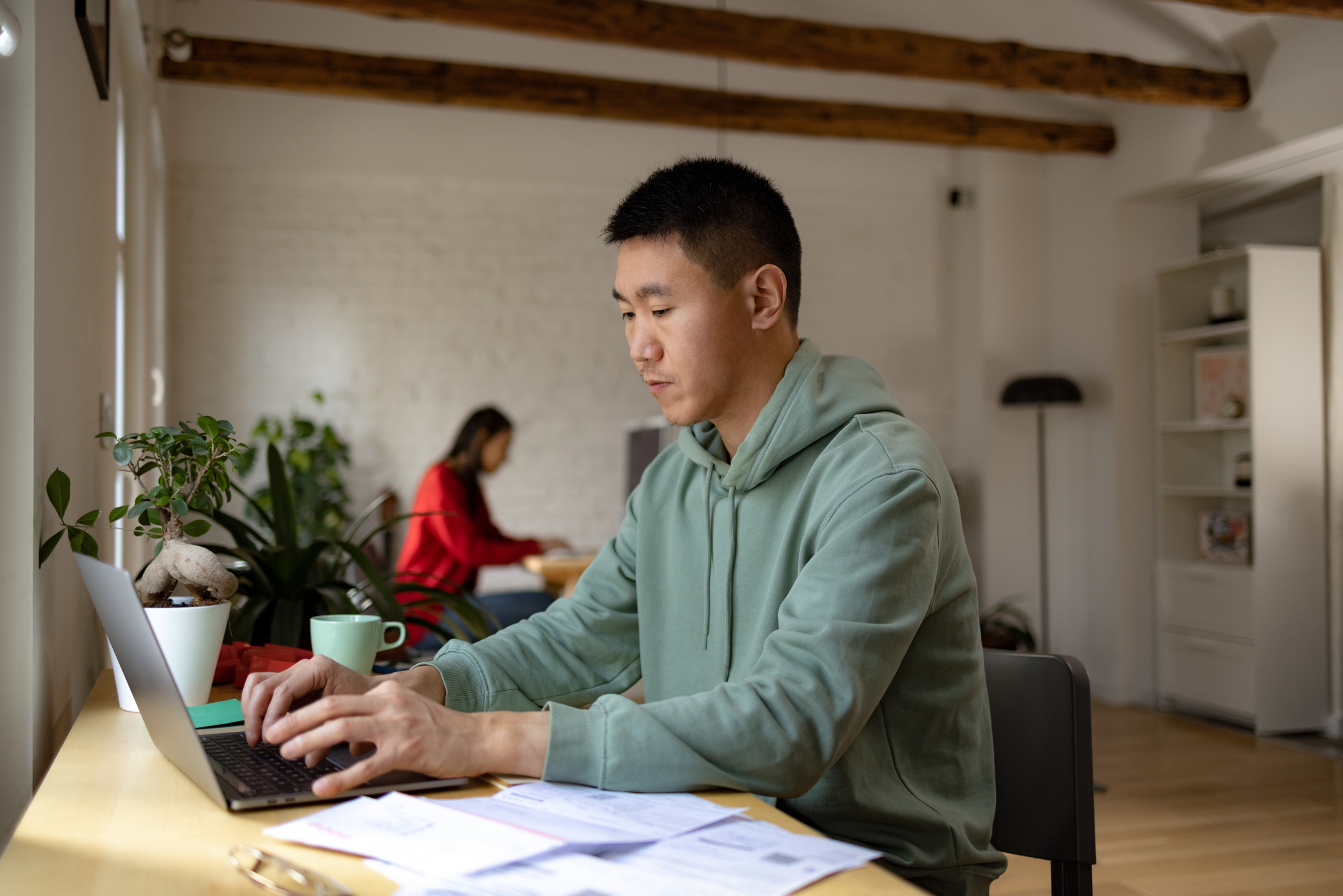 man works at laptop while doing work 
